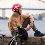Two girls sitting on wall with bikes