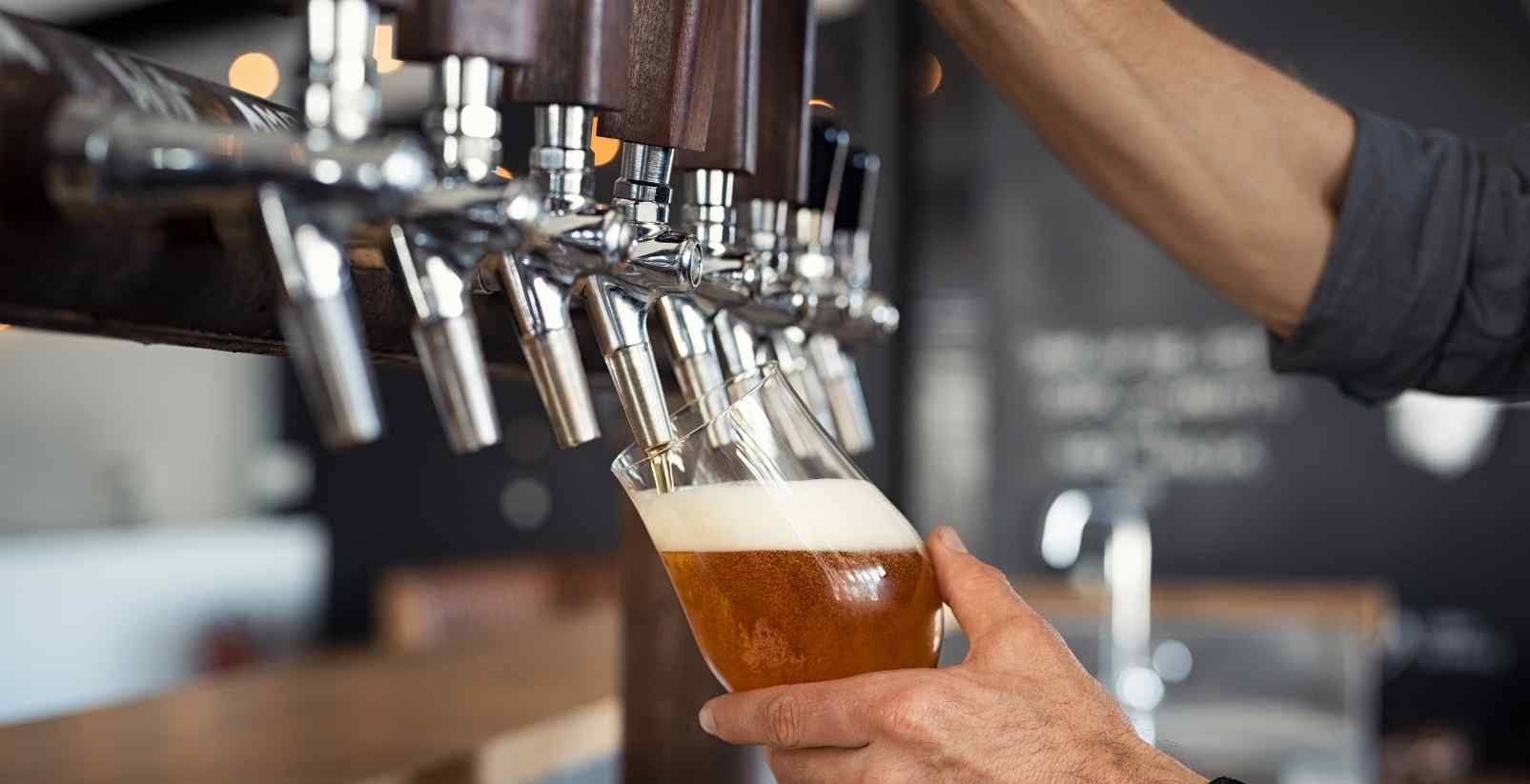 Person filling up glass with craft beer